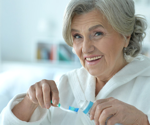 Dentures patient in Derry about to brush