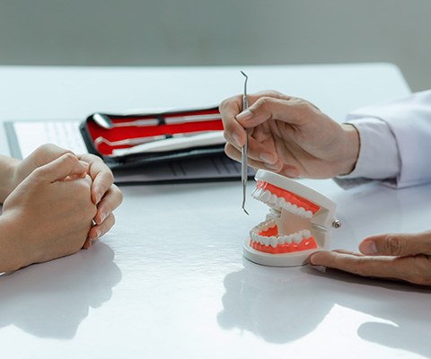 Dentist using model to explain concept to patient