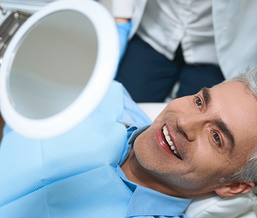 Male patient looking at smile in mirror 