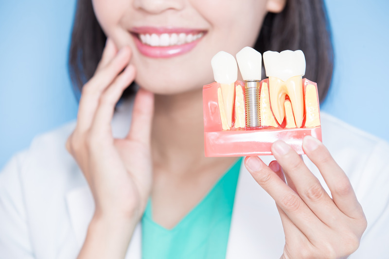 Patient looking at a model of dental implants